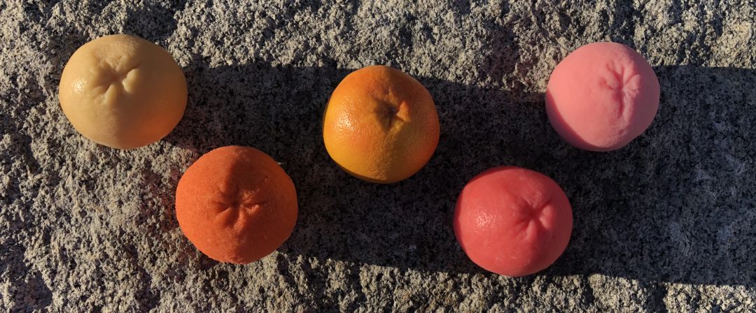 wax, rubber, sugar grapefruits in evening light on stone